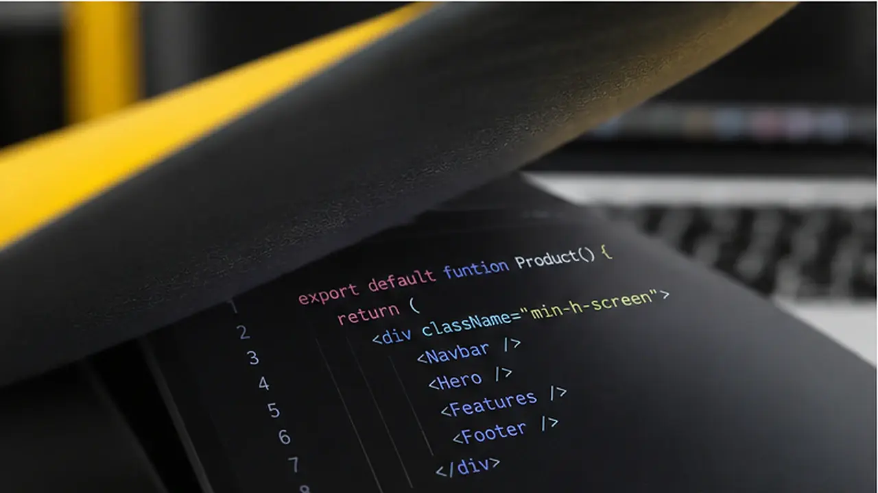 Code editor on a laptop beneath a dark notebook